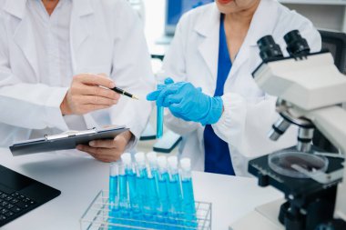 Tablet ve dizüstü bilgisayarı, laboratuarı ve çevre dostu bilimi olan iki kadın bilim adamı. Çevrimiçi okuma ile tarım, araştırma ve bilim adamları, küresel ısınma, analitik ve teknoloji için test örnekleri