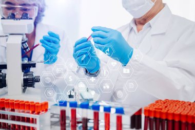 Doktor, profesyonel baş hemşire ya da cerrahla konuşuyor. Dijital tablet bilgisayar kullanıyorlar. Muhtelif sağlık uzmanları test sonucunu masada tartışıyor