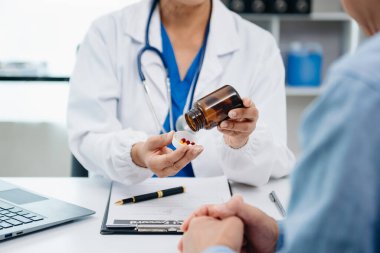 Asyalı kadınların elleri yaşlı erkeklerin ellerine dokunuyor. Ellerinde haplarla şişeyi tutarak el ele tutuşuyorlar. Okuma dersleri alıyorlar.