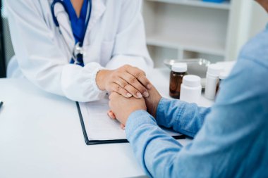 Yaşlı erkeklerin ellerine dokunan Asyalı kadın elleri, hastanedeki yaşlılara yardım ediyor.