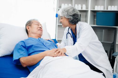 Beyaz takım elbiseli Asyalı doktor, hastanede ya da klinikte salin solüsyonu alan Asyalı yaşlıları ve yatakta yatan hastaları tartışırken not alıyor..