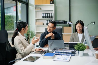 Yaratıcılık sektöründe tasarım planlama konusunda bir grup Asyalı iş toplantısı ofiste iş tartışması