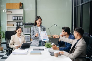 Yaratıcılık sektöründe tasarım planlama konusunda bir grup Asyalı iş toplantısı ofiste iş tartışması