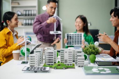 Neare 'de oturan çeşitli etnik çeşitlilikteki işadamları, konut projesinden bir yapı modeline bakıyorlar. Yeşil iş şirketi ve Güneş Enerjisi Çevre Kenti Kavramı.