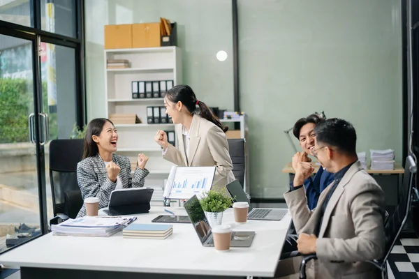 Modern bir ofiste Asyalı profesyoneller arasındaki takım çalışması ve işbirliği, kurumsal kültür, yenilik ve verimliliği gözler önüne seriyor
