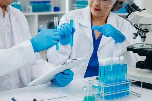 Tablet ve dizüstü bilgisayarı, laboratuarı ve çevre dostu bilimi olan iki kadın bilim adamı. Çevrimiçi okuma ile tarım, araştırma ve bilim adamları, küresel ısınma, analitik ve teknoloji için test örnekleri