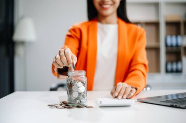 Asyalı El temiz şişe ve iş yatırımları büyüme konseptine karışık madeni para ve tohum koyuyor. Ofiste.