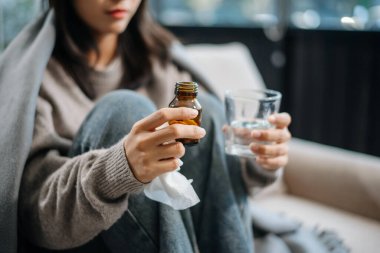 Elinde haplar olan kadın, evdeki hekiminin yazdığı ilaçları alacak.