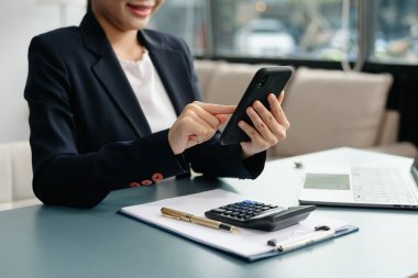 Ofiste akıllı telefon ve tablet kavramını kullanarak yeni modern bilgisayarla çalışan iş kadını.