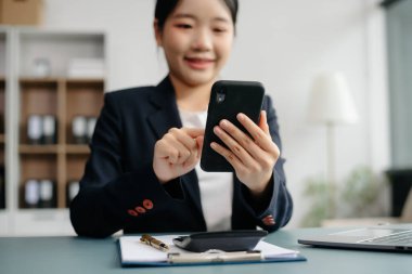 Tablet ve dizüstü bilgisayarda yazan genç ve güzel bir kadın beyaz masa modern ofisinde otururken.