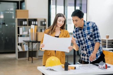 Birlikte çalışan mühendis ekipleri, mimari proje sahasında çalışan miğferler takıyor ve model ev yapıyorlar. Sektör profesyonel takımı