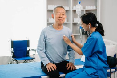 Kıdemli doktor, modern klinikte ya da hastanede muayene odasında oturup erkek hastalarla konuşup gülmeyi tartışıyor.