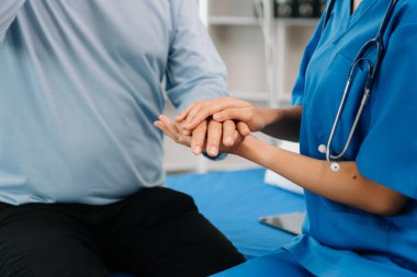 Asyalı kadın elleri yaşlı erkeğin ellerine dokunuyor hastanede yaşlılara yardım eden eller