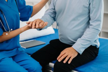 Asyalı kadın elleri yaşlı erkeğin ellerine dokunuyor hastanede yaşlılara yardım eden eller