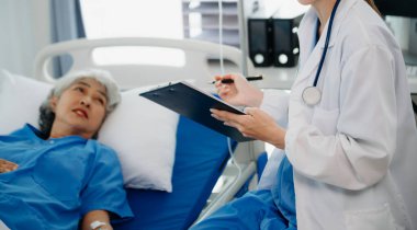 Gülümseyen beyaz bir doktor hastanedeki genç bir hastayla ilgileniyor. Dost canlısı hemşire ya da tedavi edici müşteri Profesyonel Tıp Hizmetleri konsepti