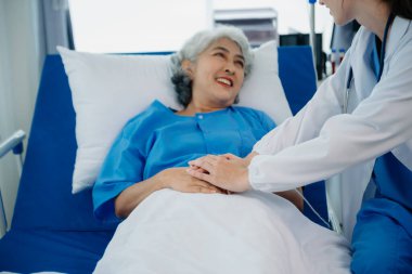 Gülümseyen beyaz bir doktor hastanedeki genç bir hastayla ilgileniyor. Dost canlısı hemşire ya da tedavi edici müşteri Profesyonel Tıp Hizmetleri konsepti