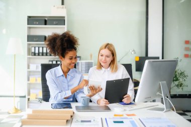 Bayan, erkek meslektaşımla yeni projeyi tartışıyor. Genç bayan ofiste iş kadınıyla konuşuyor..
