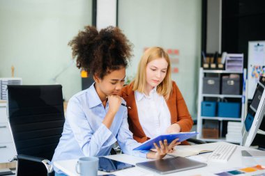 Bayan, erkek meslektaşımla yeni projeyi tartışıyor. Genç bayan ofiste iş kadınıyla konuşuyor..