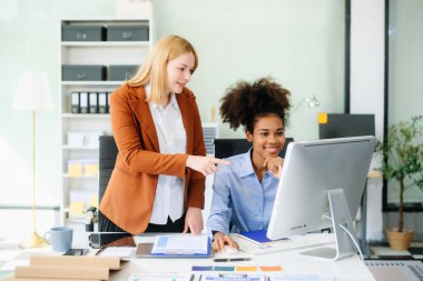 Bayan, erkek meslektaşımla yeni projeyi tartışıyor. Genç bayan ofiste iş kadınıyla konuşuyor..
