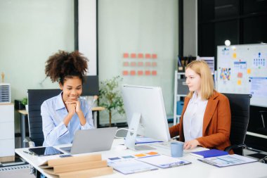 Bayan, erkek meslektaşımla yeni projeyi tartışıyor. Genç bayan ofiste iş kadınıyla konuşuyor..