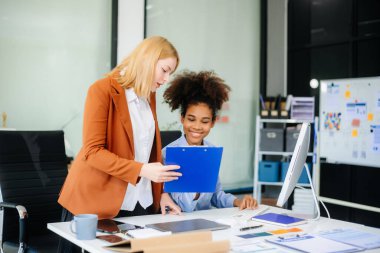 Bayan, erkek meslektaşımla yeni projeyi tartışıyor. Genç bayan ofiste iş kadınıyla konuşuyor..