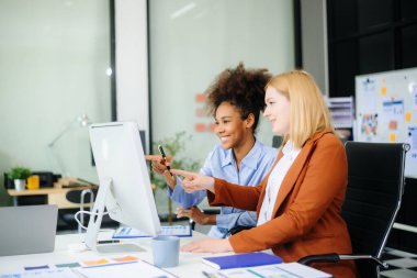 Bayan, erkek meslektaşımla yeni projeyi tartışıyor. Genç bayan ofiste iş kadınıyla konuşuyor..