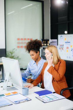 Bayan, erkek meslektaşımla yeni projeyi tartışıyor. Genç bayan ofiste iş kadınıyla konuşuyor..