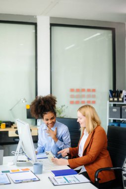 Bayan, erkek meslektaşımla yeni projeyi tartışıyor. Genç bayan ofiste iş kadınıyla konuşuyor..