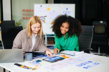 İş adamları ofiste toplanıyor. Çalışan beyin fırtınası ve takım olarak çalışmak, kağıt ve tablet üzerinde projeyi planlamak ve tartışmak.