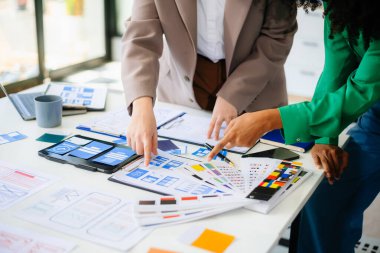 İş adamları ofiste toplanıyor. Çalışan beyin fırtınası ve takım olarak çalışmak, kağıt ve tablet üzerinde projeyi planlamak ve tartışmak.