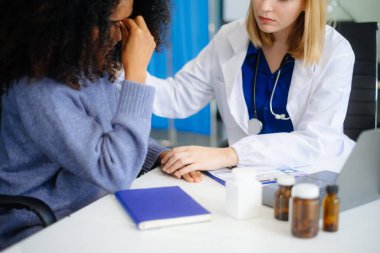 Profesyonel bir doktor, sonuçları ya da belirtileri tartışmak için konuşur ve erkek hastaya tavsiye verir ve randevu ziyaretinde sağlık belgesini imzalar.