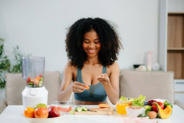 Sağlıklı bir yaşam tarzı için taze meyve ve sebzeleri karıştıran bir kadının hayat dolu bir sağlık sahnesini keşfedin. Fitness, beslenme ve temiz yeme temaları için mükemmel.