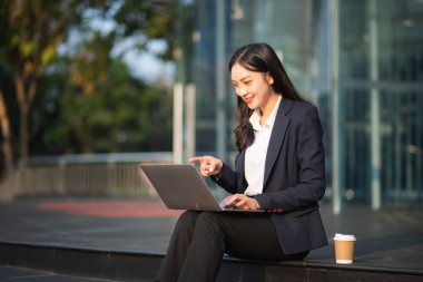 Çalışan kadın konsepti. Video konferansına katılan ve elinde tablet, smatrphone ve kahve tutan bir kadın menajer.