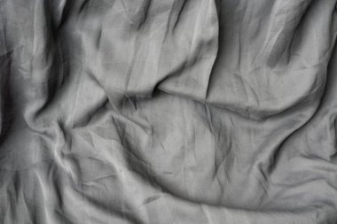 Kırışmış gri / siyah sentetik şifon ya da saf kumaşın tam kare arkaplan dokusu. Yumuşak, dalgalı kıvrımlar dramatik, soyut bir gölge ve ışık deseni yaratır..