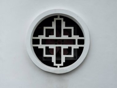 Geometrik kafes desenli, beyaz dairesel mozaik pencereye yakın çekim. Klasik Asya tasarımını temiz, minimalist estetikle birleştiren geleneksel doğu mimari ayrıntıları.