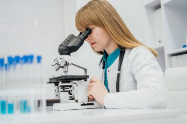 Bilimin ileri düzey biyomedikal kariyerlerine cinsiyet dahil edilmesini ve büyüyen kadın varlığının sağlık teknolojisi sektörlerini vurgulayan laboratuvar örneklerini analiz eden profesyonel tıp araştırmacısı.