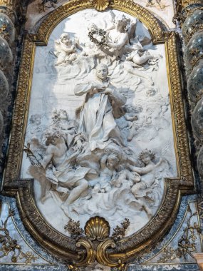 Süslü barok beyaz mermer yüksek çözünürlüklü panelde bir aziz, melekler ve meleklerle çevrili, Roma kilisesinde özenle hazırlanmış oval bir çerçevede..