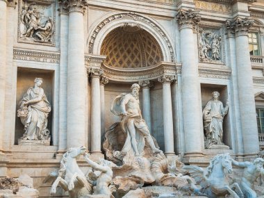 Roma 'daki Trevi Çeşmesi' nin ön cephesi Neptün 'ü deniz atları ve tritonlarla dolu, alegorik heykeller, süslü kemer ve Latince yazıtlarla çevrili savaş arabasında gösteriyor..