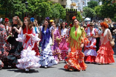  Romeria San Bernabe, Marbella sırasında flamenko elbiseleri giyerek sokakta yürüyen kadınlar.