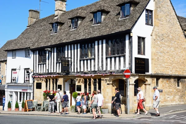 Touristen stehen vor Burford House Teestuben entlang der Hügel Einkaufsstraße, Burford. — Stockfoto