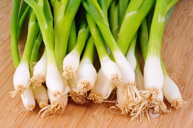 Ahşap doğrama tahtası üzerinde beyaz soğan demet.