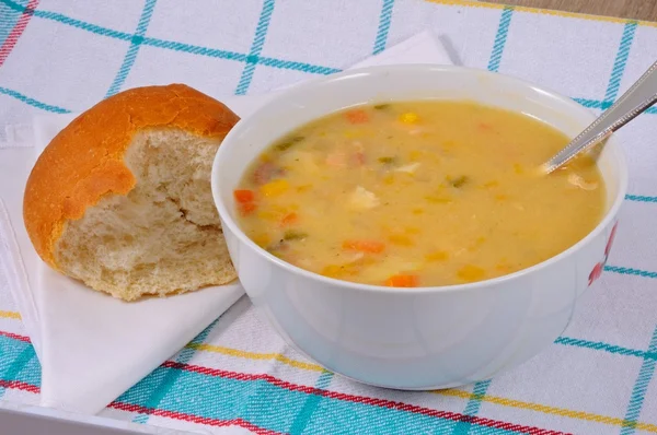 Homemade fish chowder soup with a bread roll.