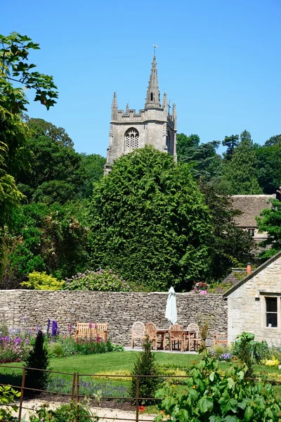 Vista da torre da igreja de St Andrews com um belo jardim em primeiro plano, Castle Combe . — Fotografia de Stock