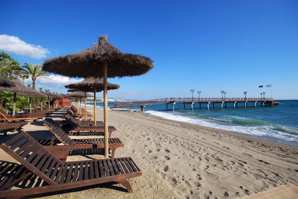 Camas de sol vazias e guarda-sol na praia, Daitona Beach, Marbella . — Fotografia de Stock