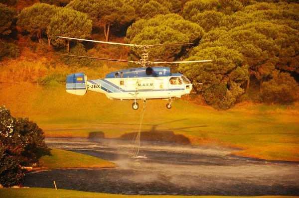 Kamov ka-32a11bc Hubschrauber (Registrierung ec-jsq), der Löschwasser aus einem Golfplatzsee sammelt, cabopino. — Stockfoto