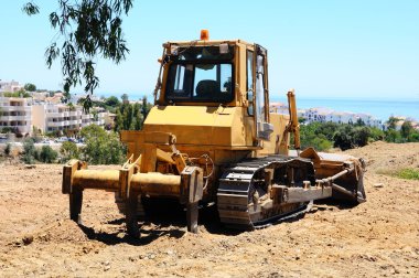 Sarı buldozer Karındeşen arkada, Costa del Sol gösterilen boş arazi Park.