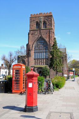 View of the Abbey Church of Saint Peter and Saint Paul with an old post box and telephone box in the foreground, Shrewsbury. clipart