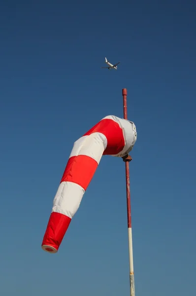 Röda och vita windsock med A320 flygplan till baksidan. — Stockfoto