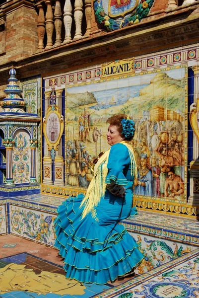 Mulher de vestido tradicional sentado em um banco de cerâmica na Plaza de Espana, Sevilha — Fotografia de Stock