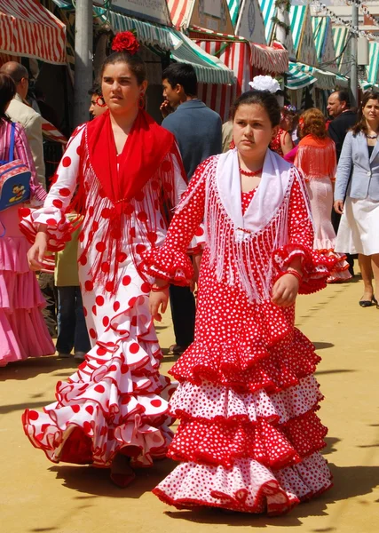 Girls walking alongside Casitas in traditional dress at the Seville Fair, Seville. — Stock Photo, Image